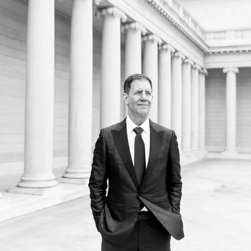 Doug stands in a courtyard surrounded by building columns.