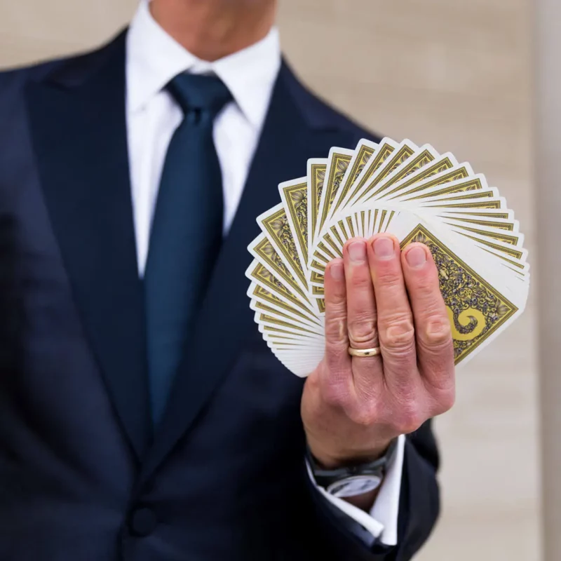 Doug holds a deck of fanned cards in his hand.