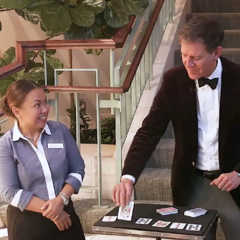 Doug engages and audience volunteer with a card trick.